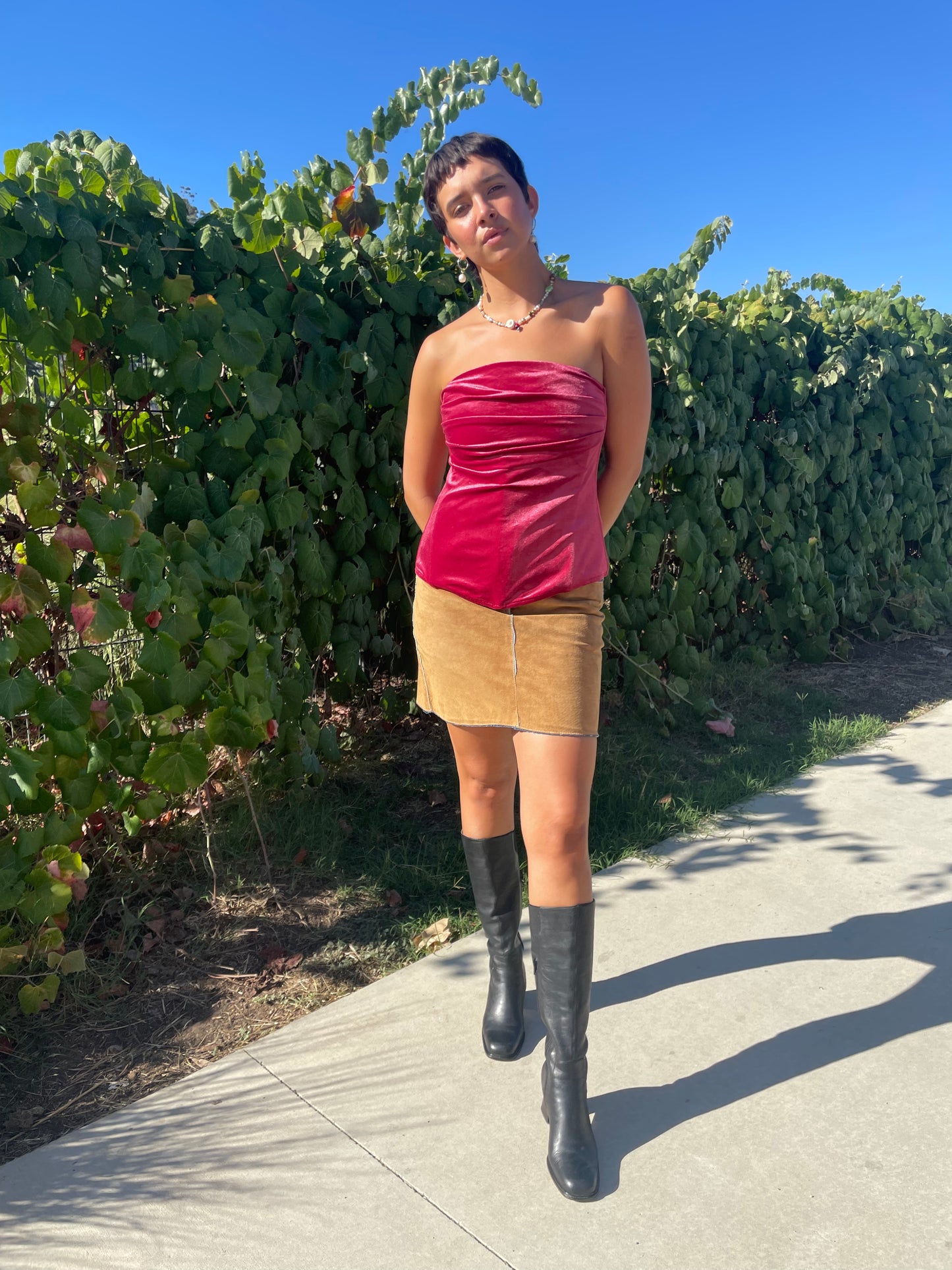 girl wearing pink velvet corset and tan skirt