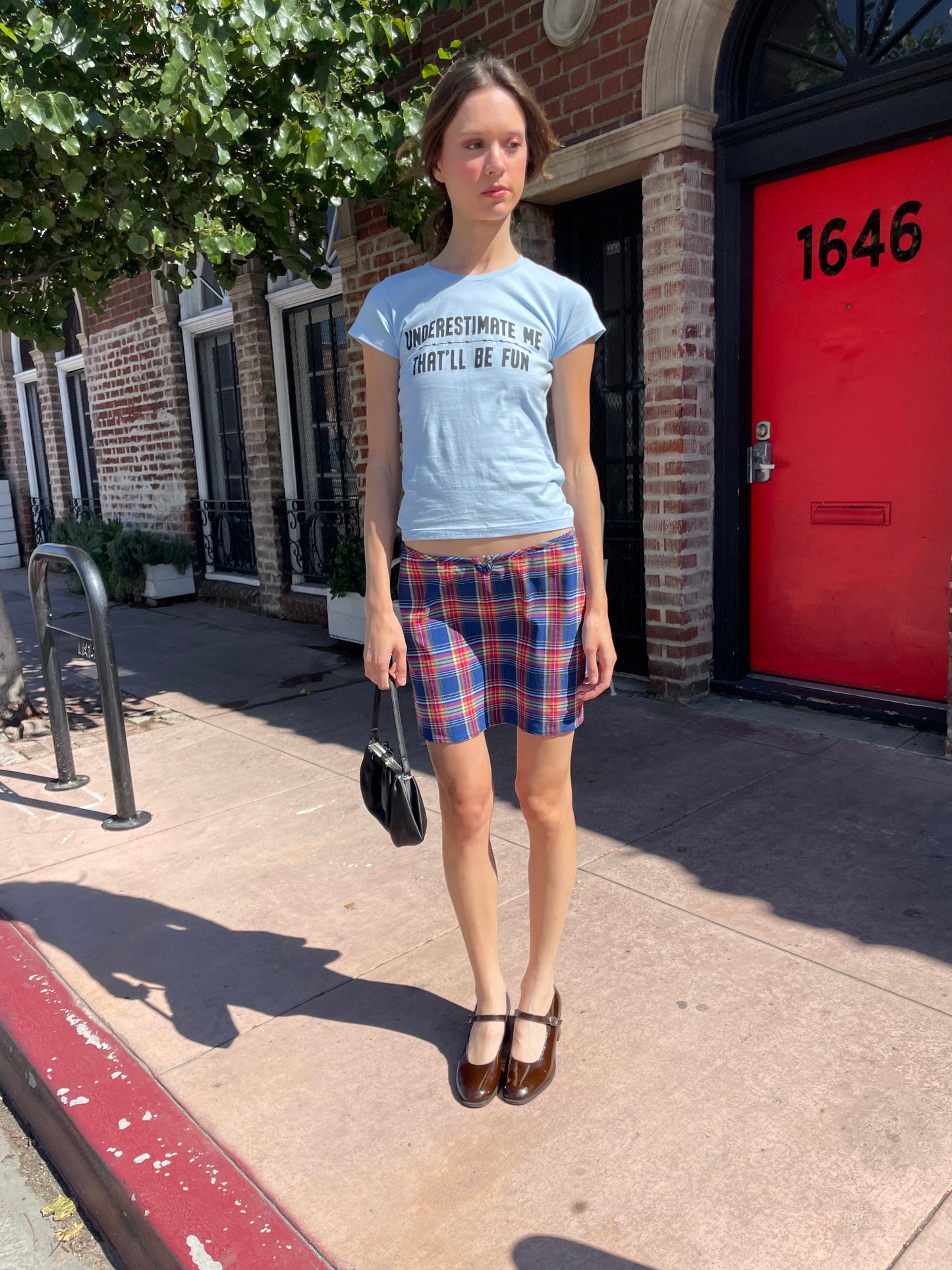 girl in blue t-shirt and plaid skirt