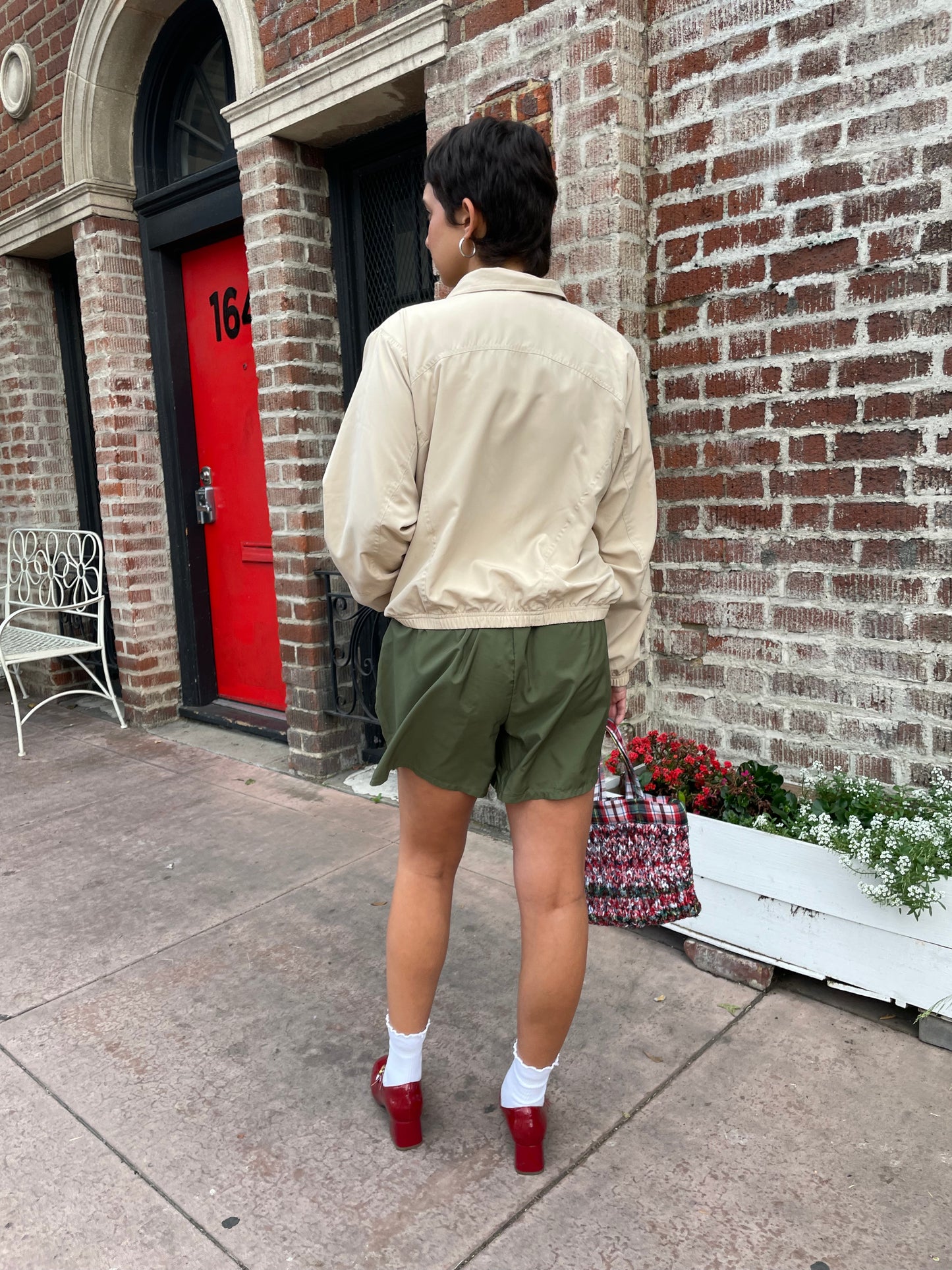 girl in green shorts and tan jacket
