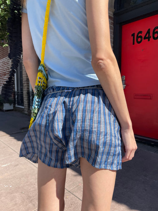 girl in blue t-shirt and plaid shorts