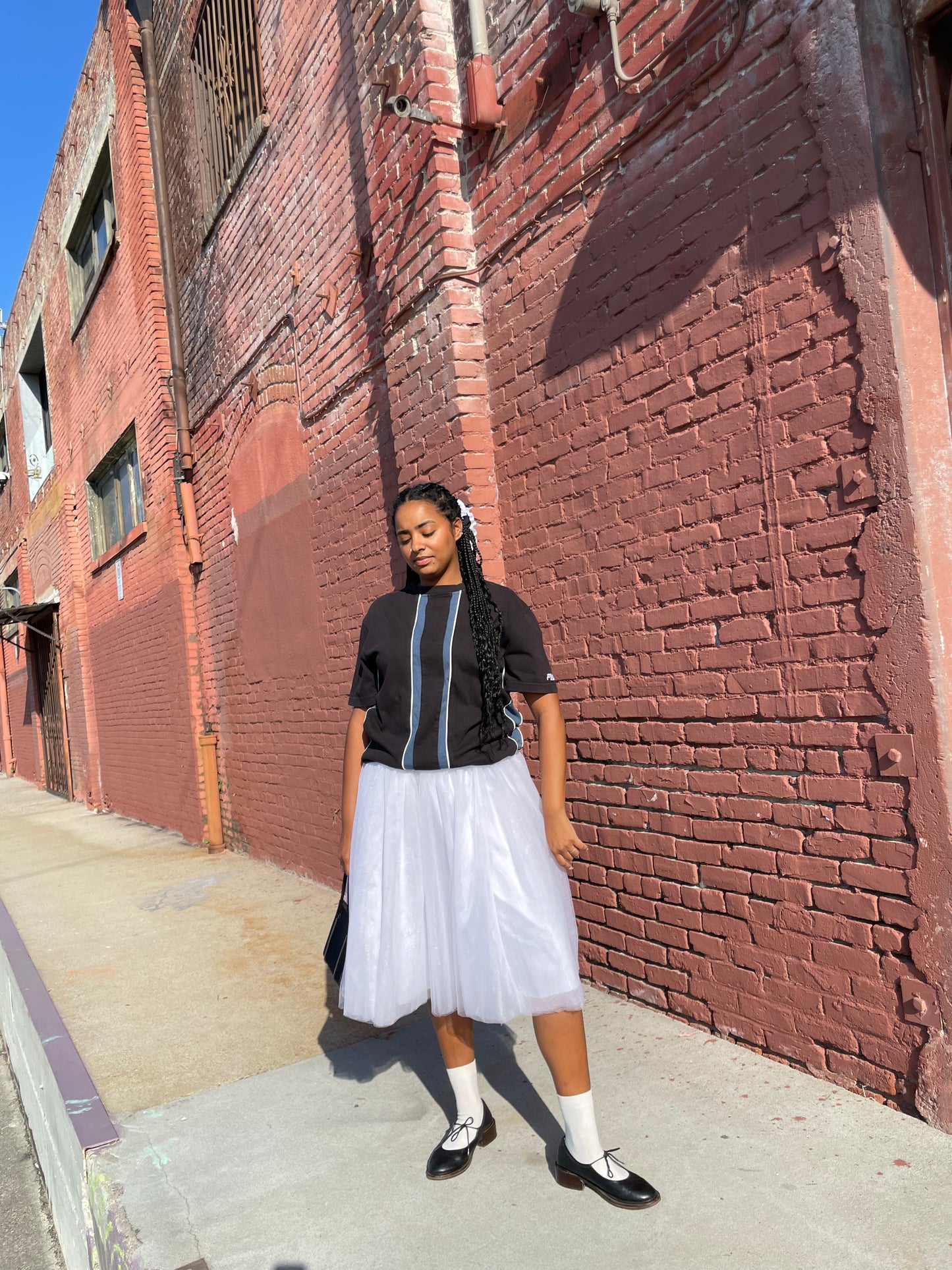 girl wearing 90s fila racing stripe t shirt