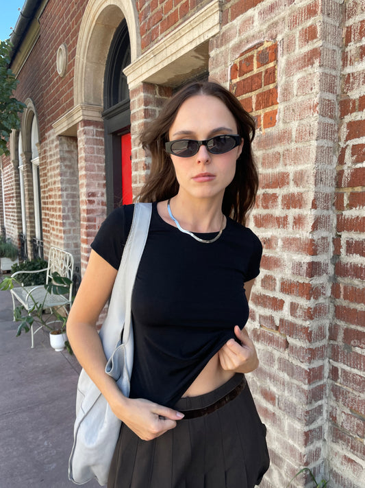 girl in cropped black top and brown skirt