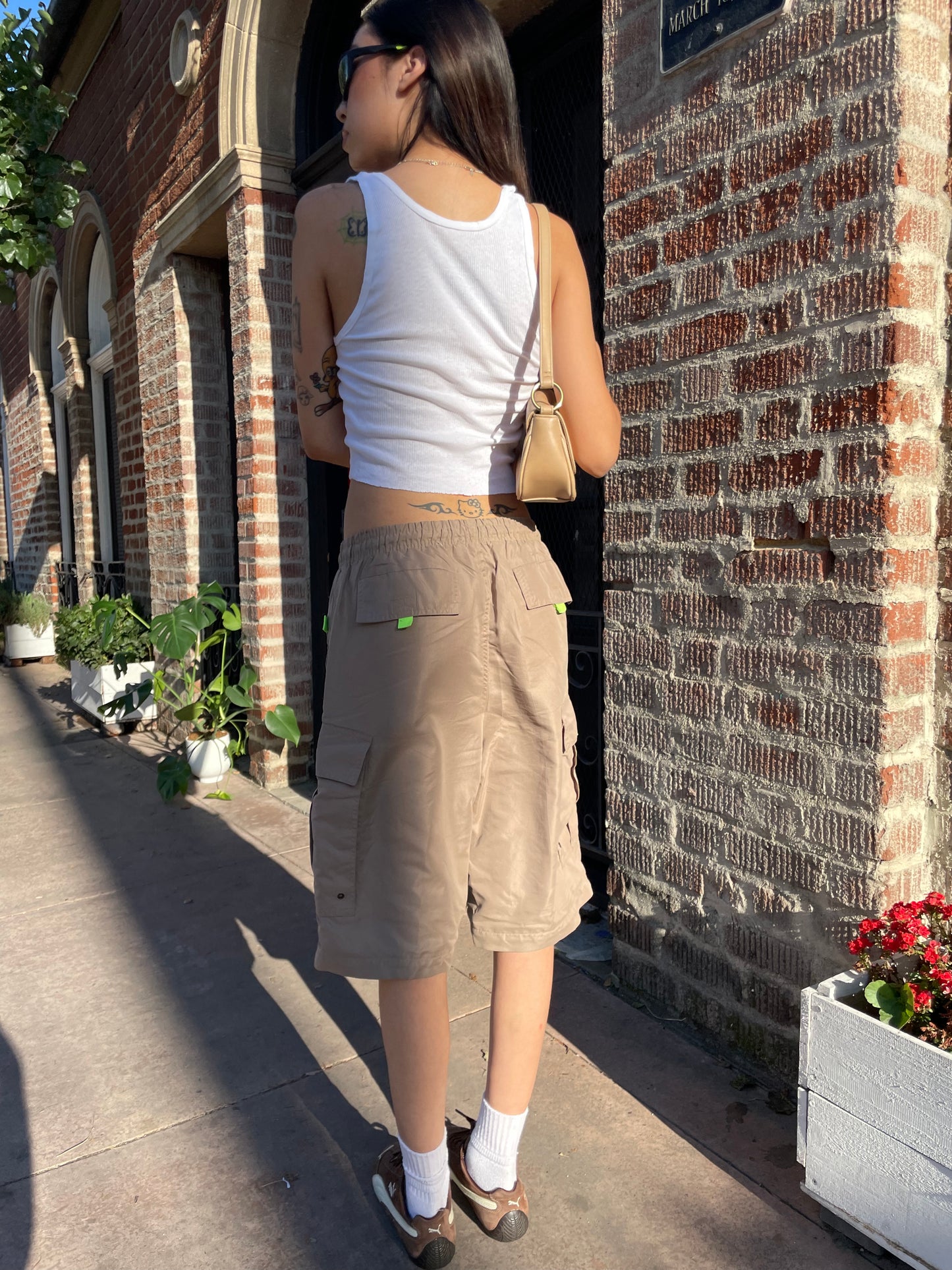 girl in white tank top and tan shorts