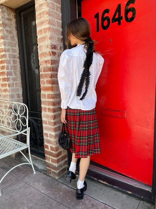 girl in white button down and red plaid skirt