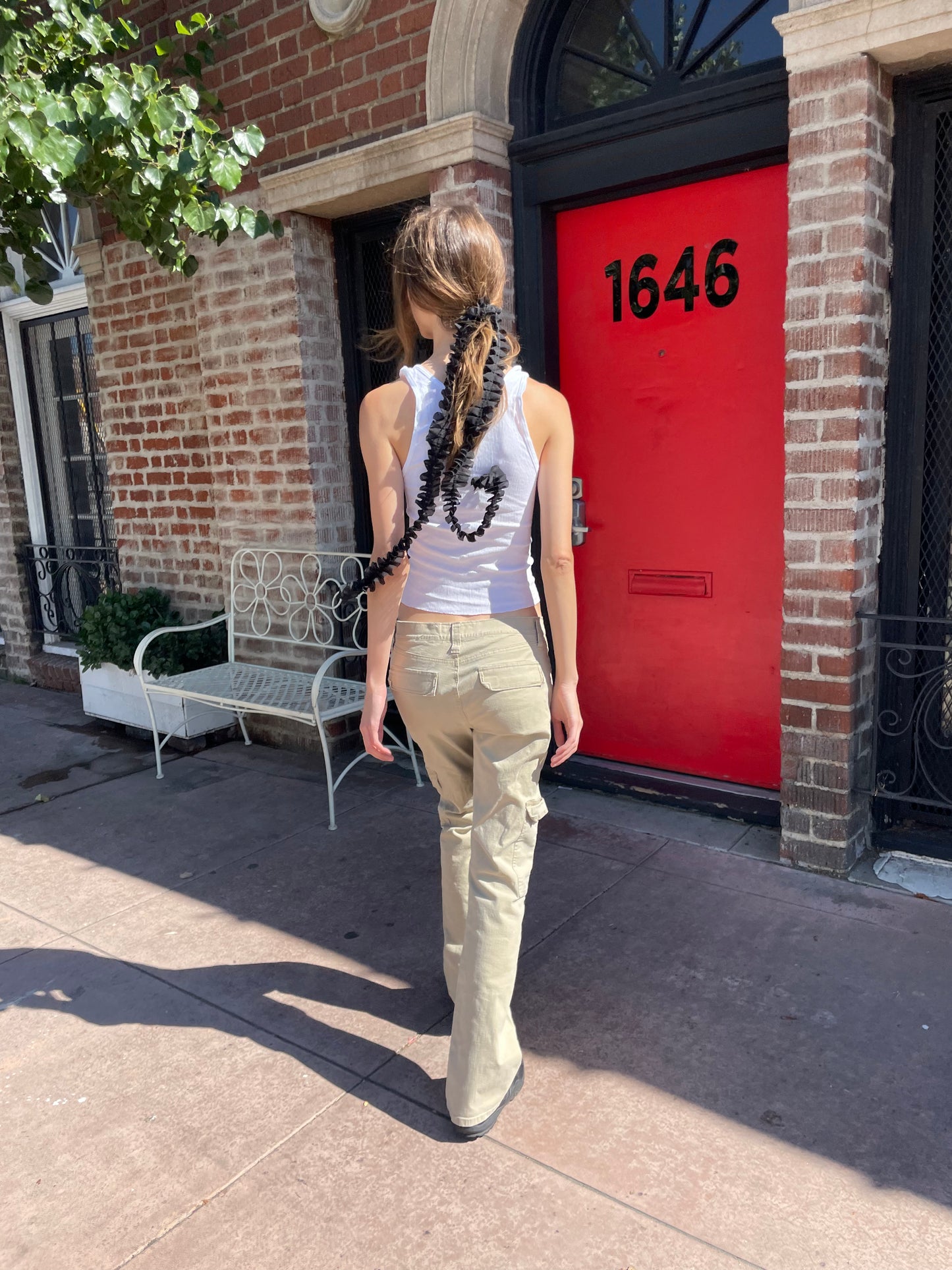 girl in white tank top and tan cargo pants