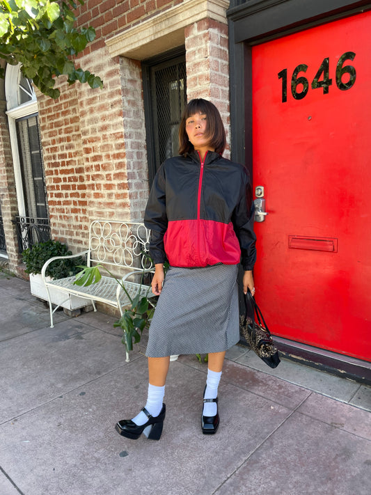 girl in striped skirt and black and red jacket