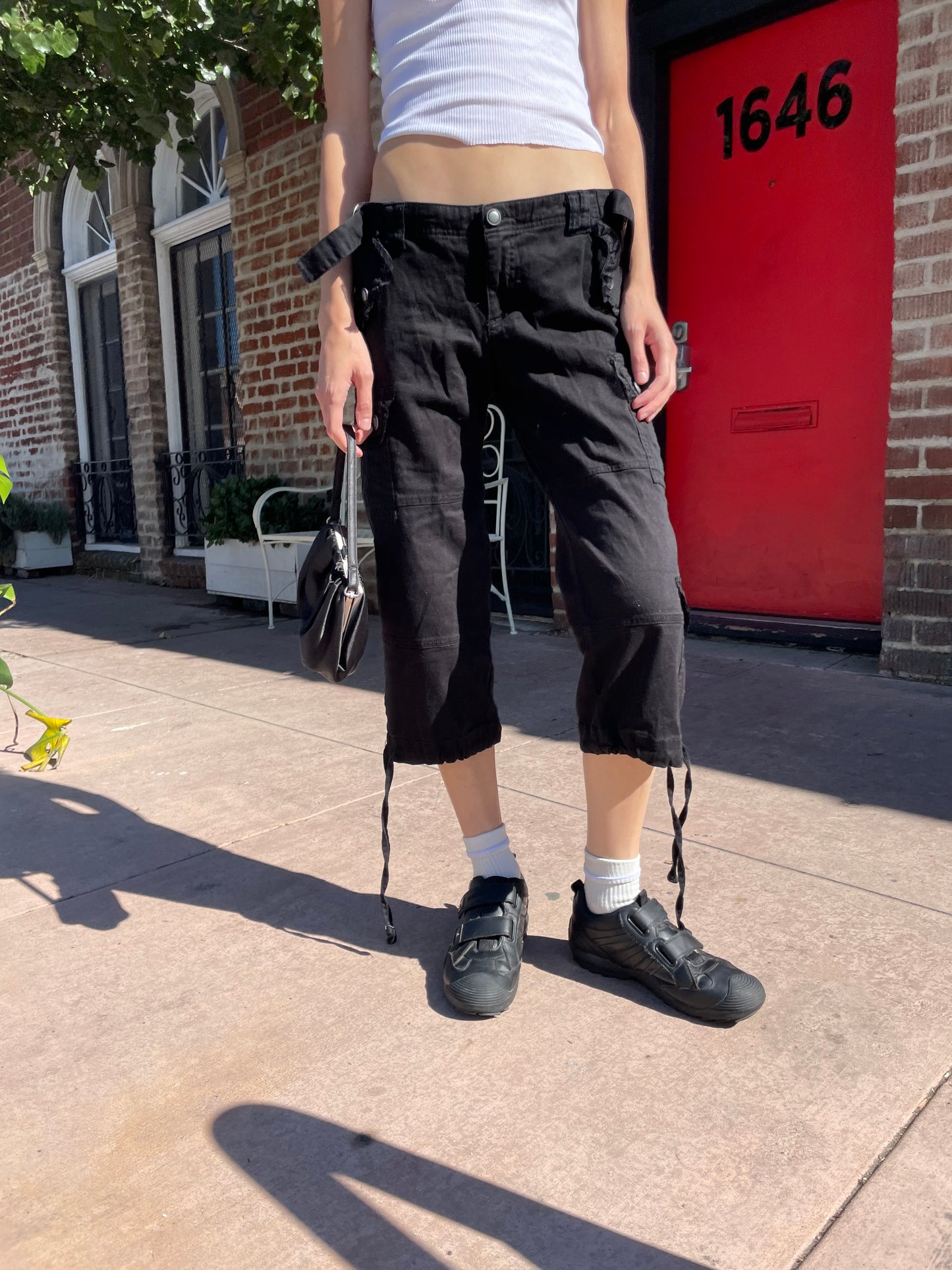 girl in white tank top and black cargo capris