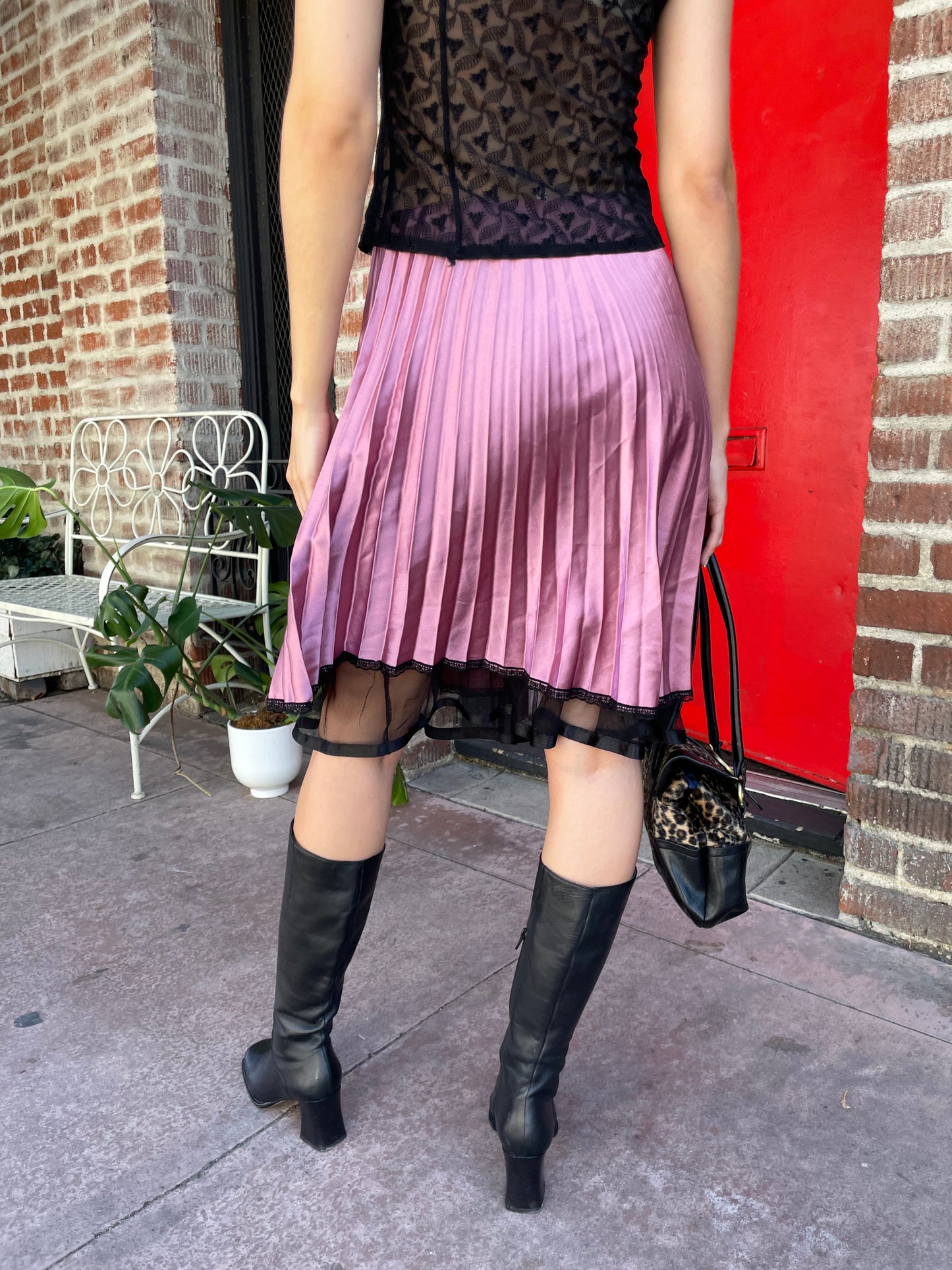 girl in pink satin pleated skirt and black top
