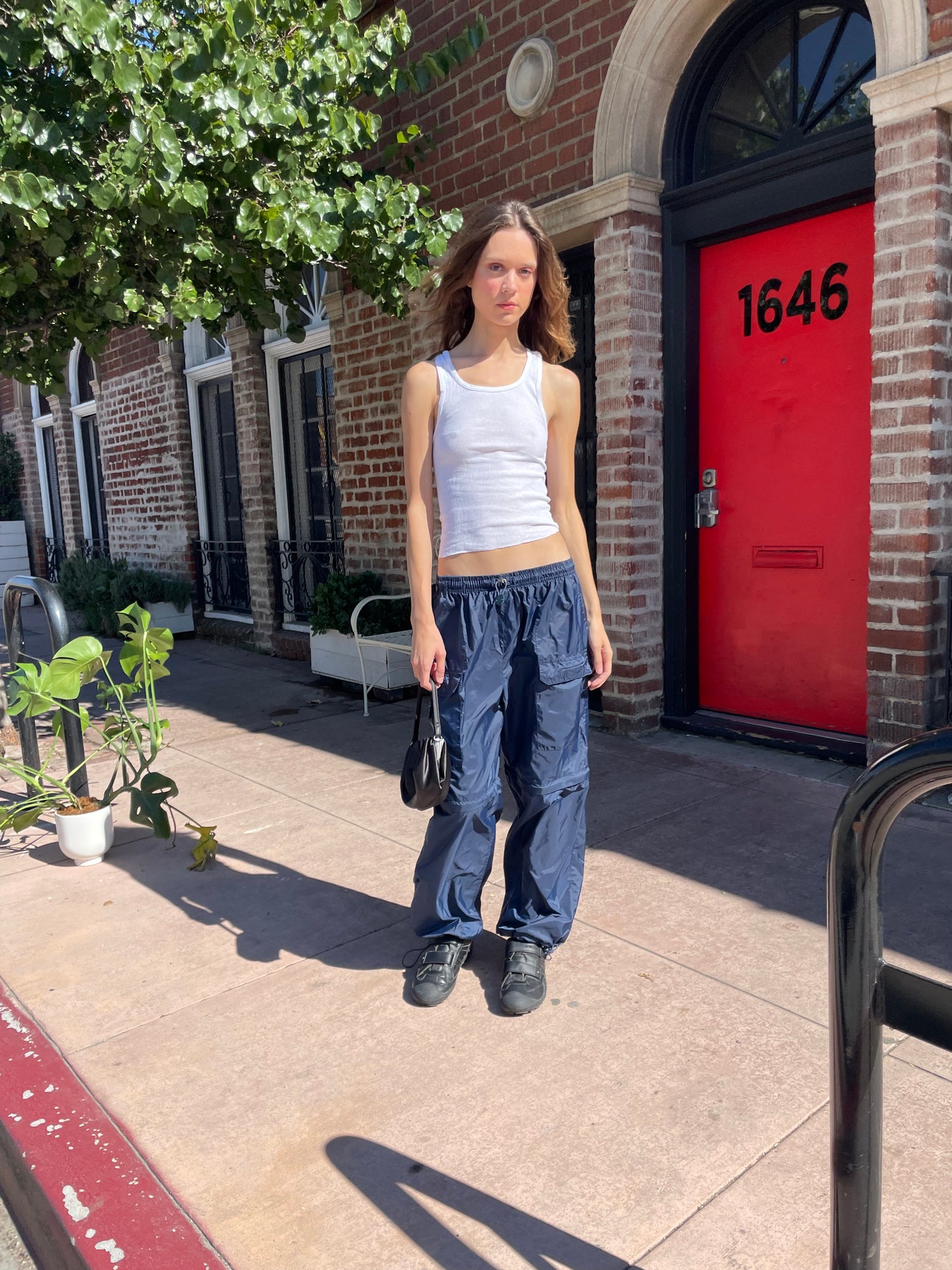 girl in white tank top and blue cargo pants