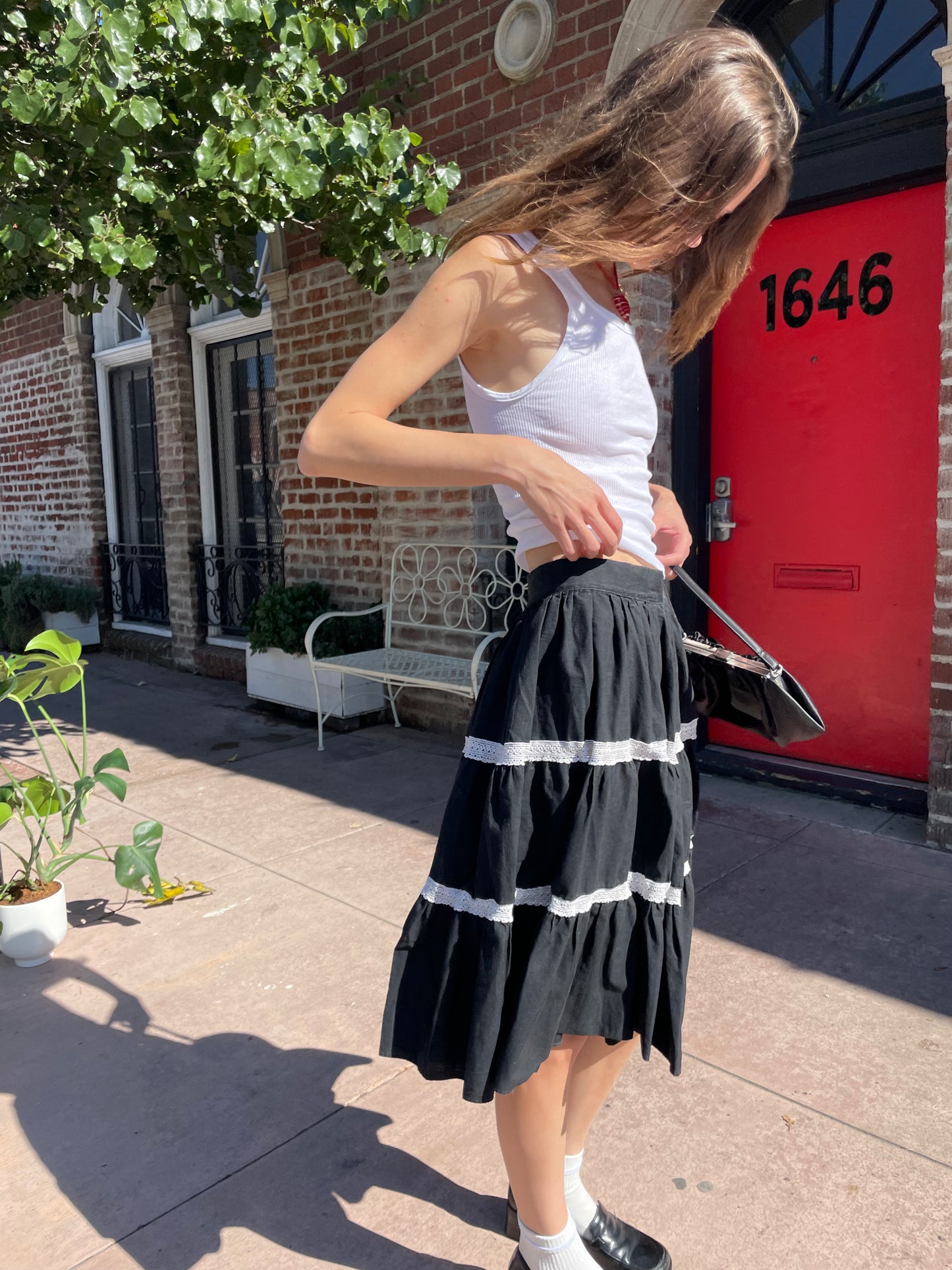 girl in white tank top and black skirt