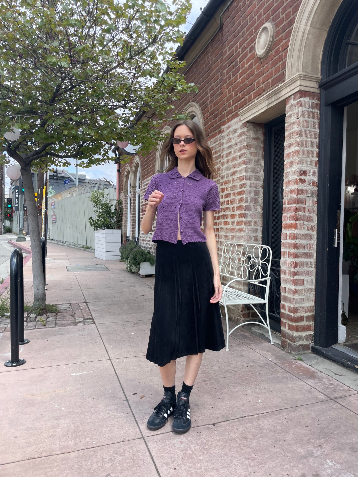 girl wearing purple button up top and long black skirt
