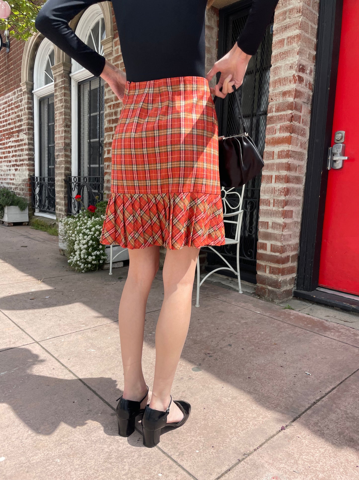 girl wearing long sleeve black shirt and red plaid skirt