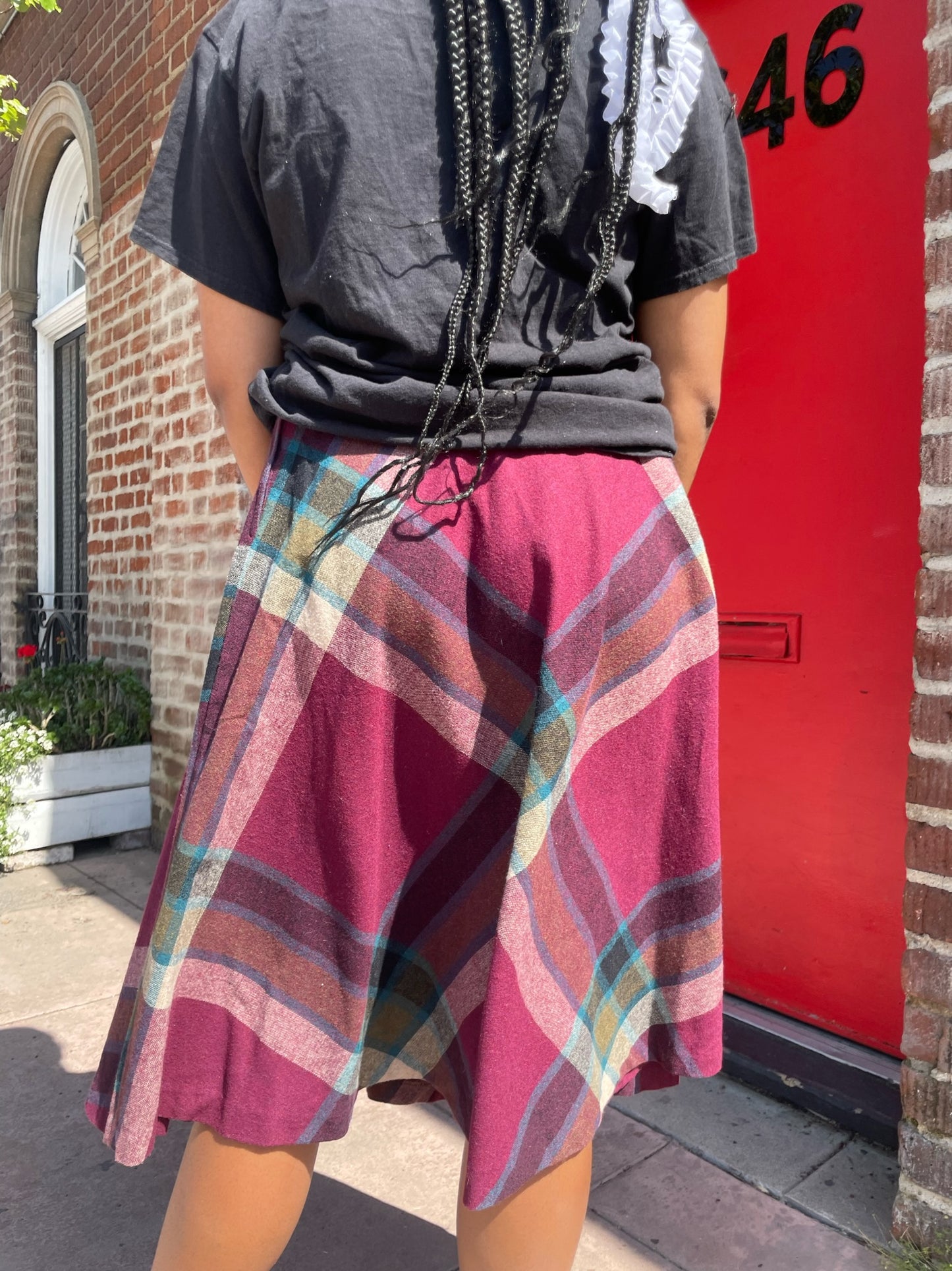 girl wearing a black t shirt and red skirt