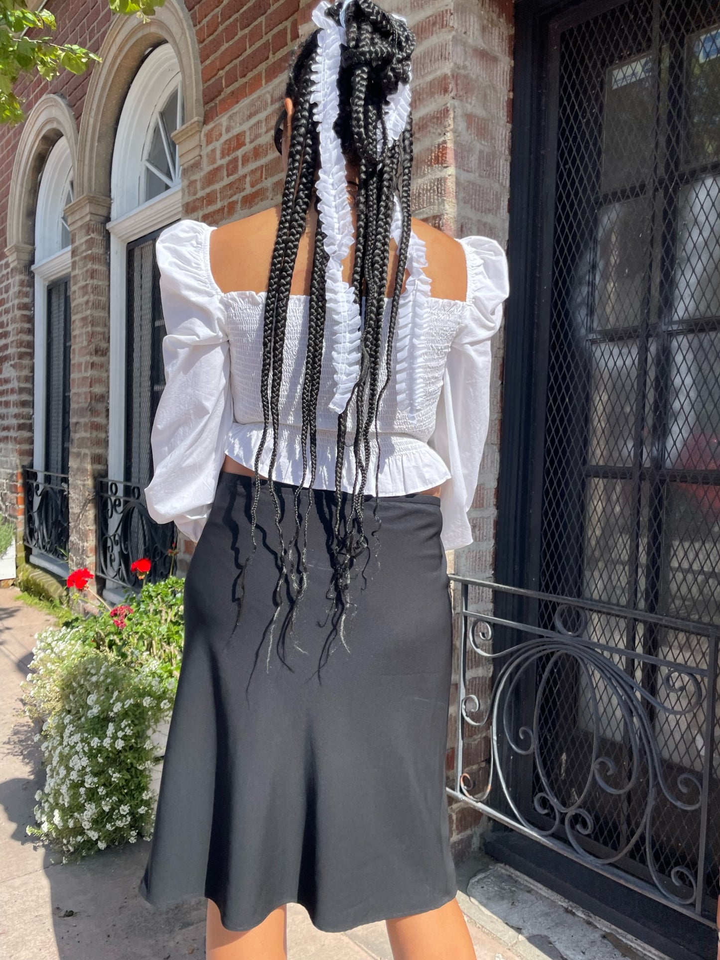 back of girl wearing white shirt and black skirt
