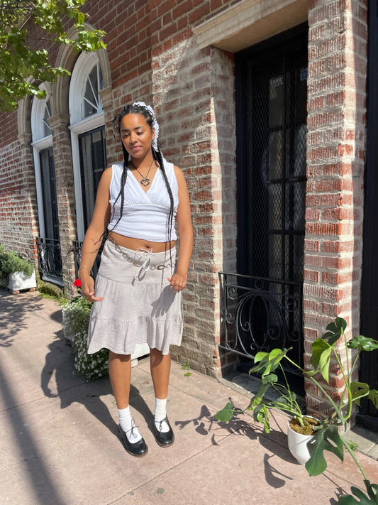 girl in white tank and tan skirt