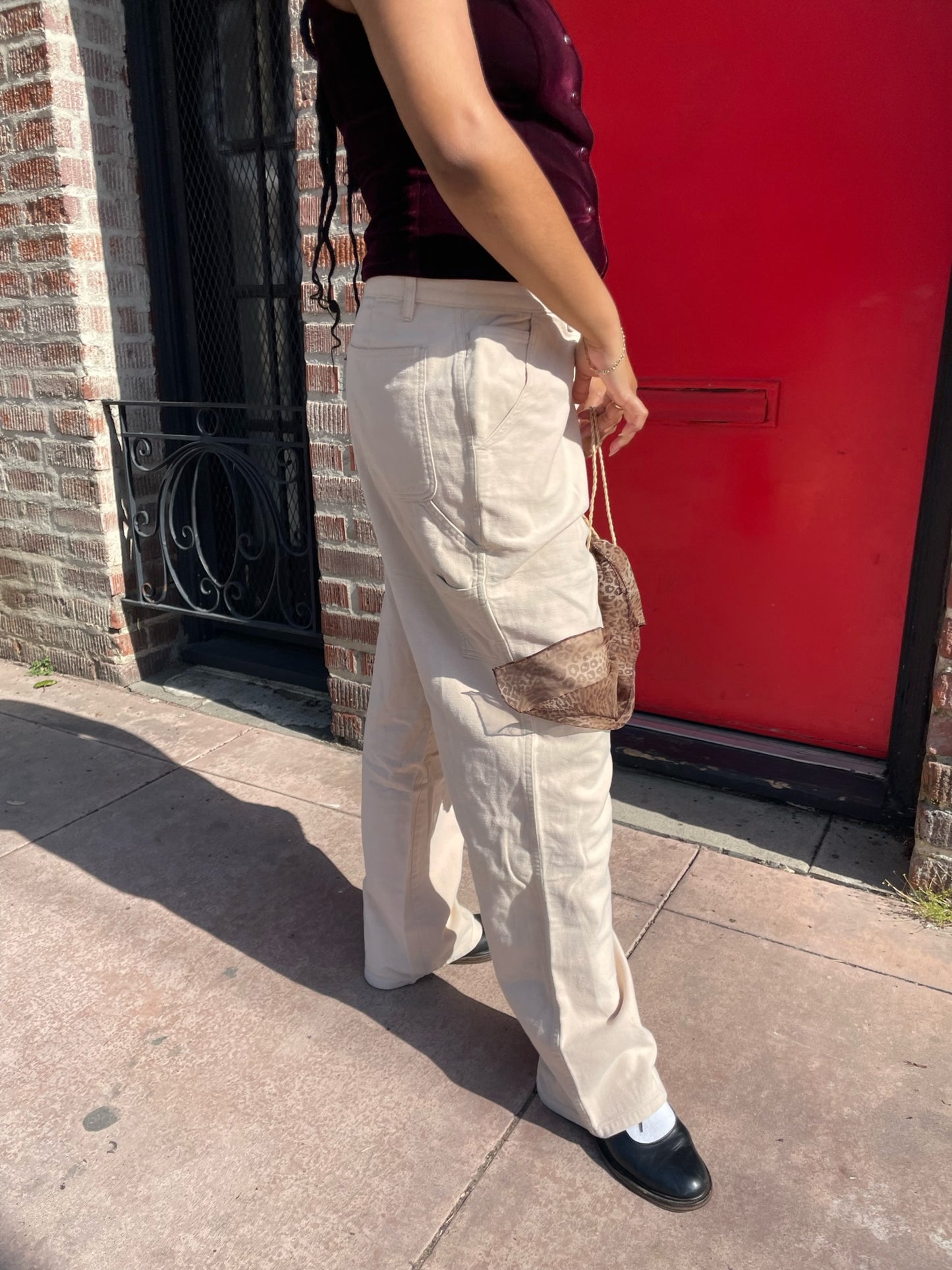 girl wearing red velvet vest and white pants