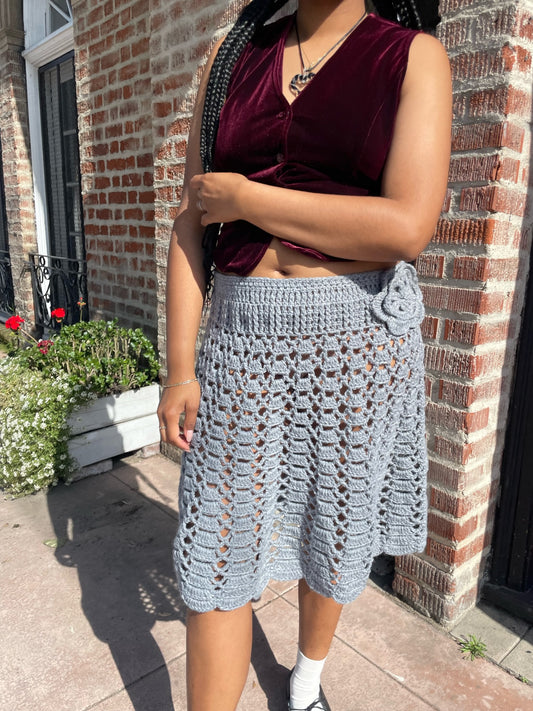 girl wearing red velvet vest and light blue crochet skirt