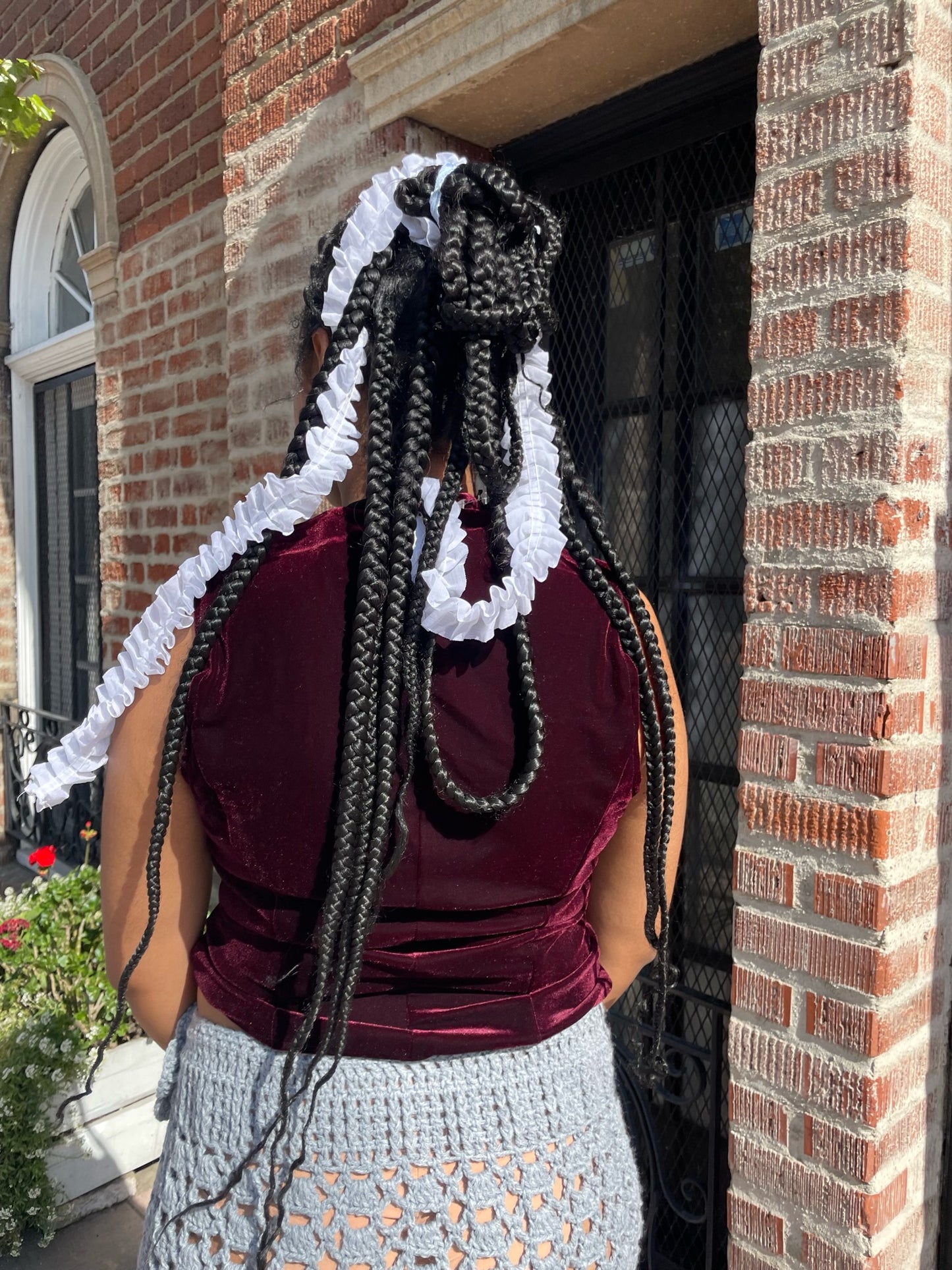 girl wearing red velvet vest and light blue crochet skirt