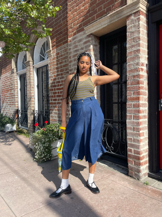 girl wearing long blue jean skirt and crochet purse and white yellow and black striped shirt