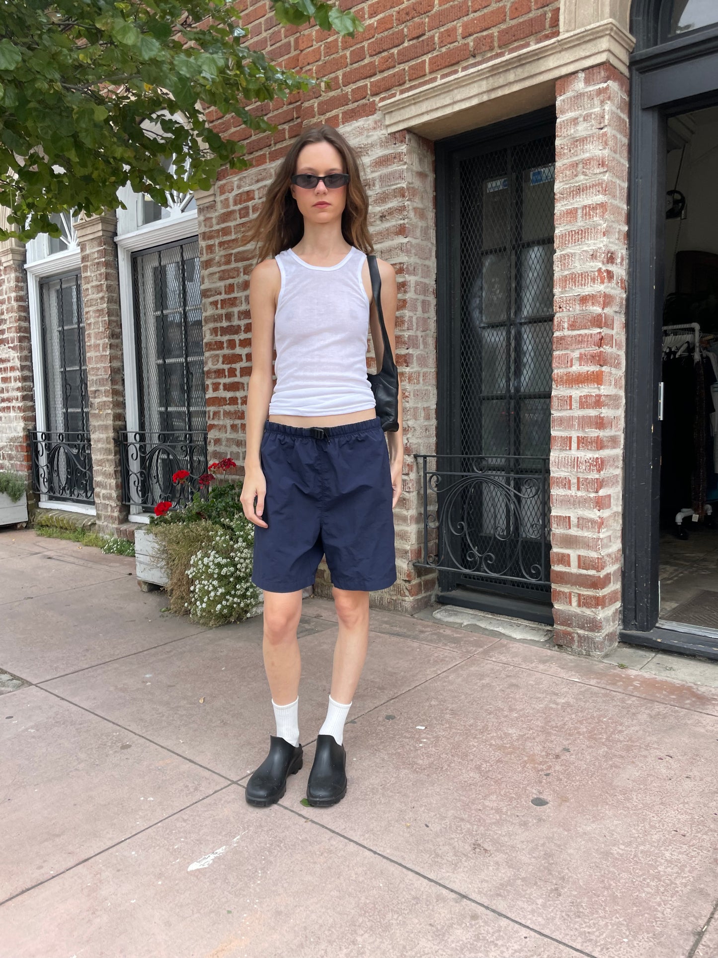 girl wearing white tank top and blue shorts