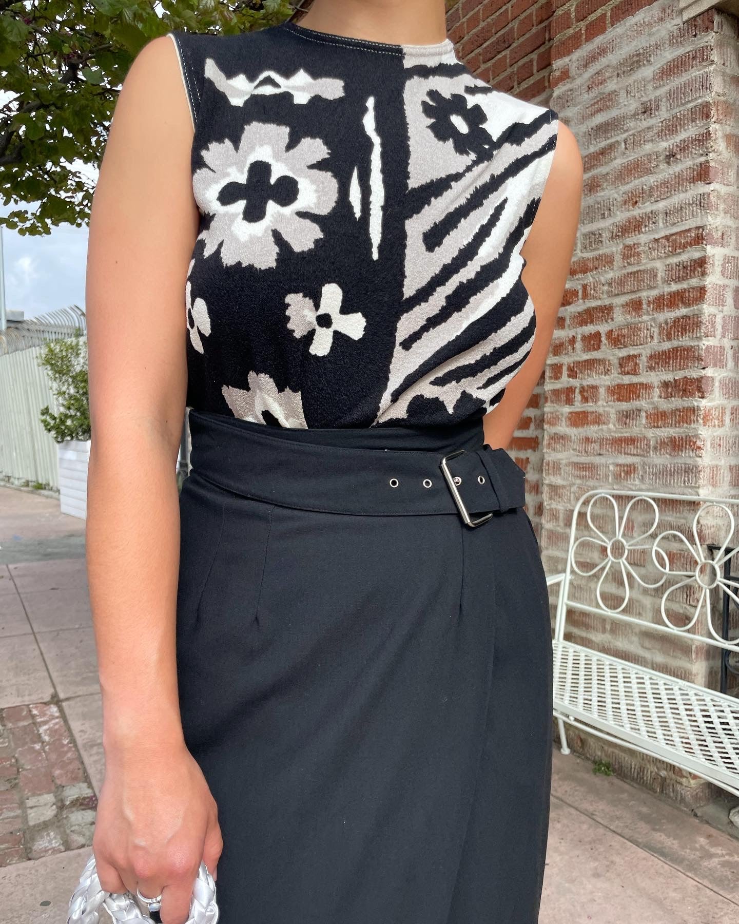 girl wearing black and white top and black skirt and white handbag