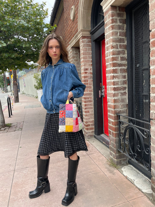 girl wearing denim jacket, gingham skirt and black boots