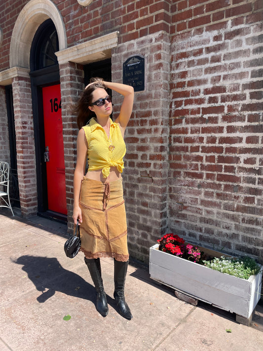 girl in tan leather skirt and yellow top