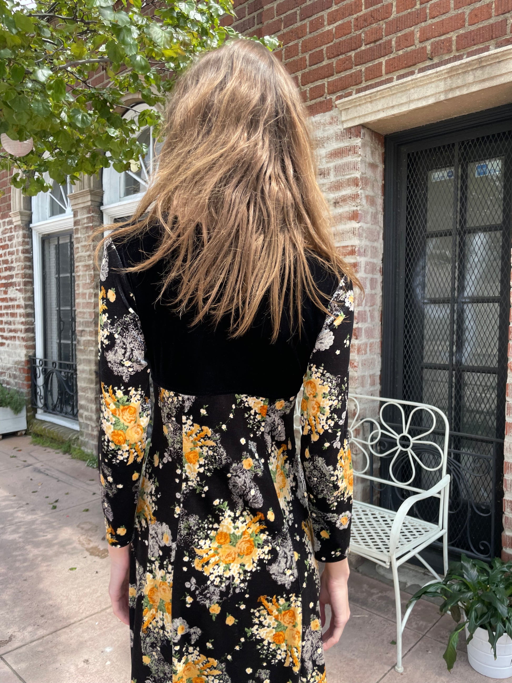 back of girl wearing long sleeve black and yellow dress