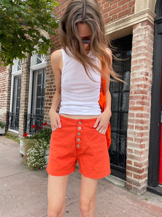 girl in white tank and orange shorts