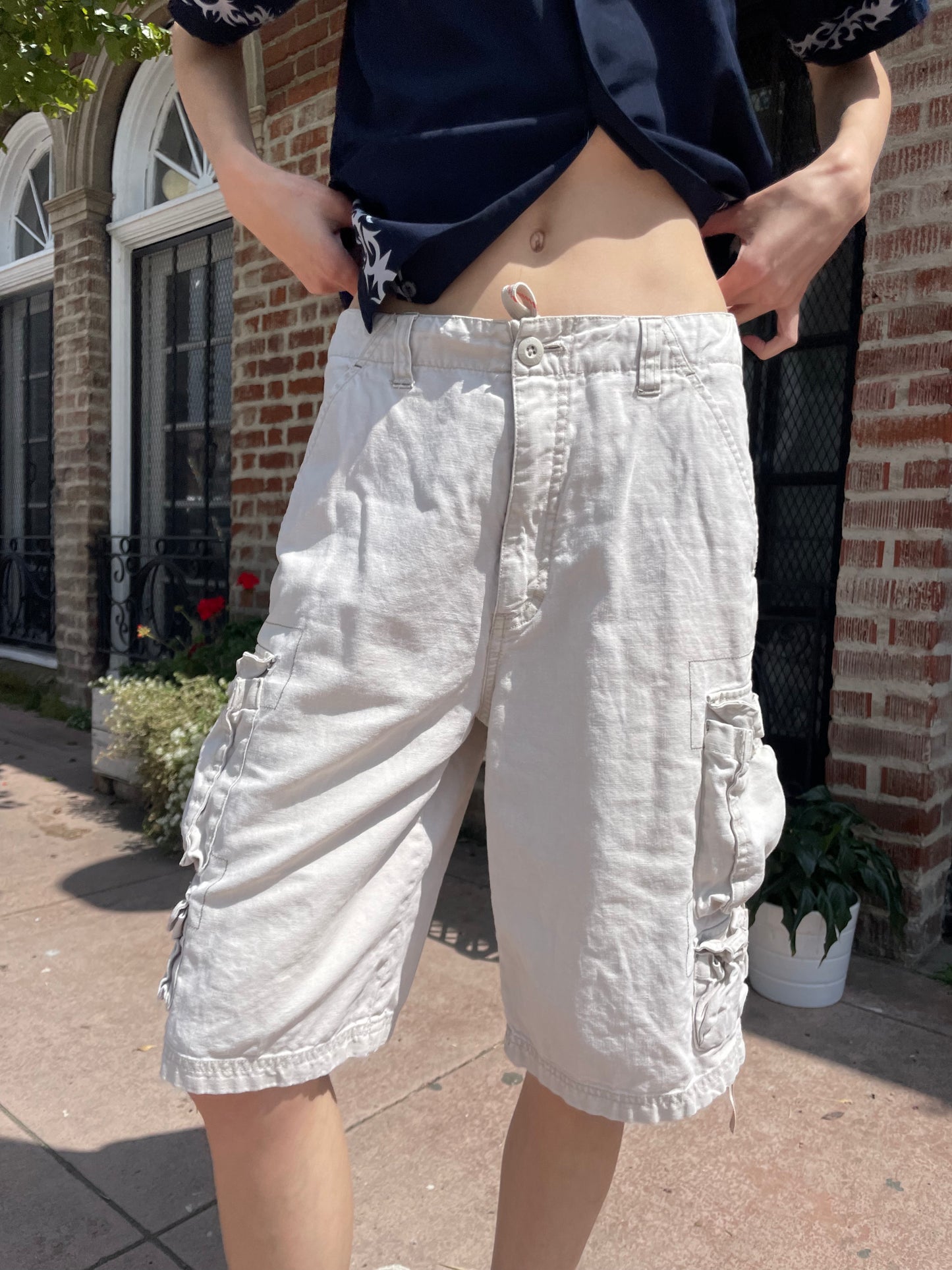 girl wearing blue button up shirt and khaki cargo shorts