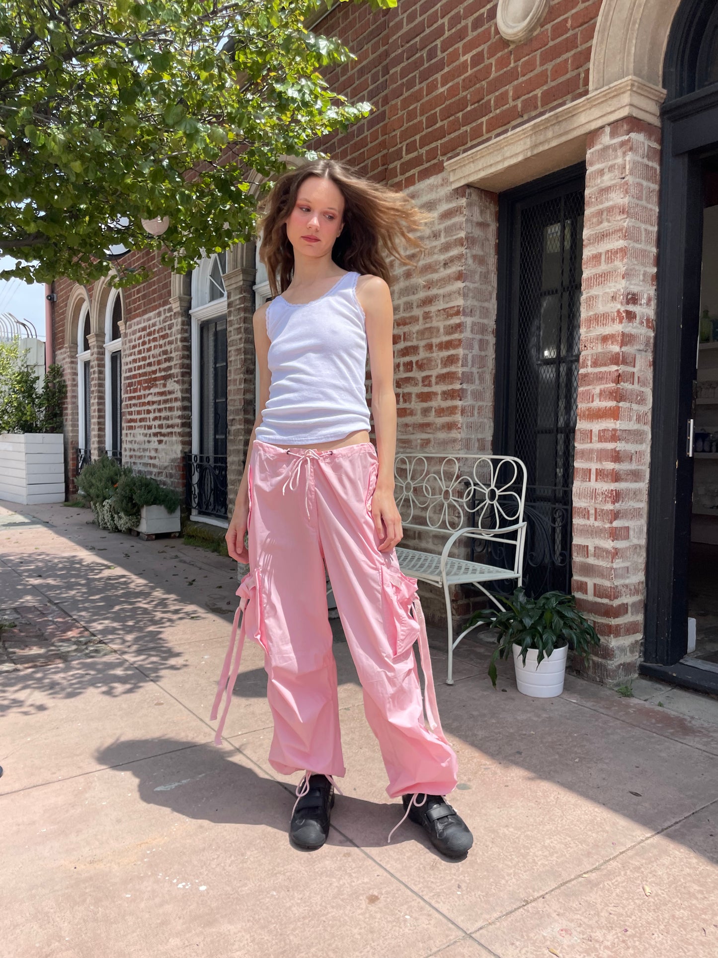 girl wearing baggy pink pants and white tank