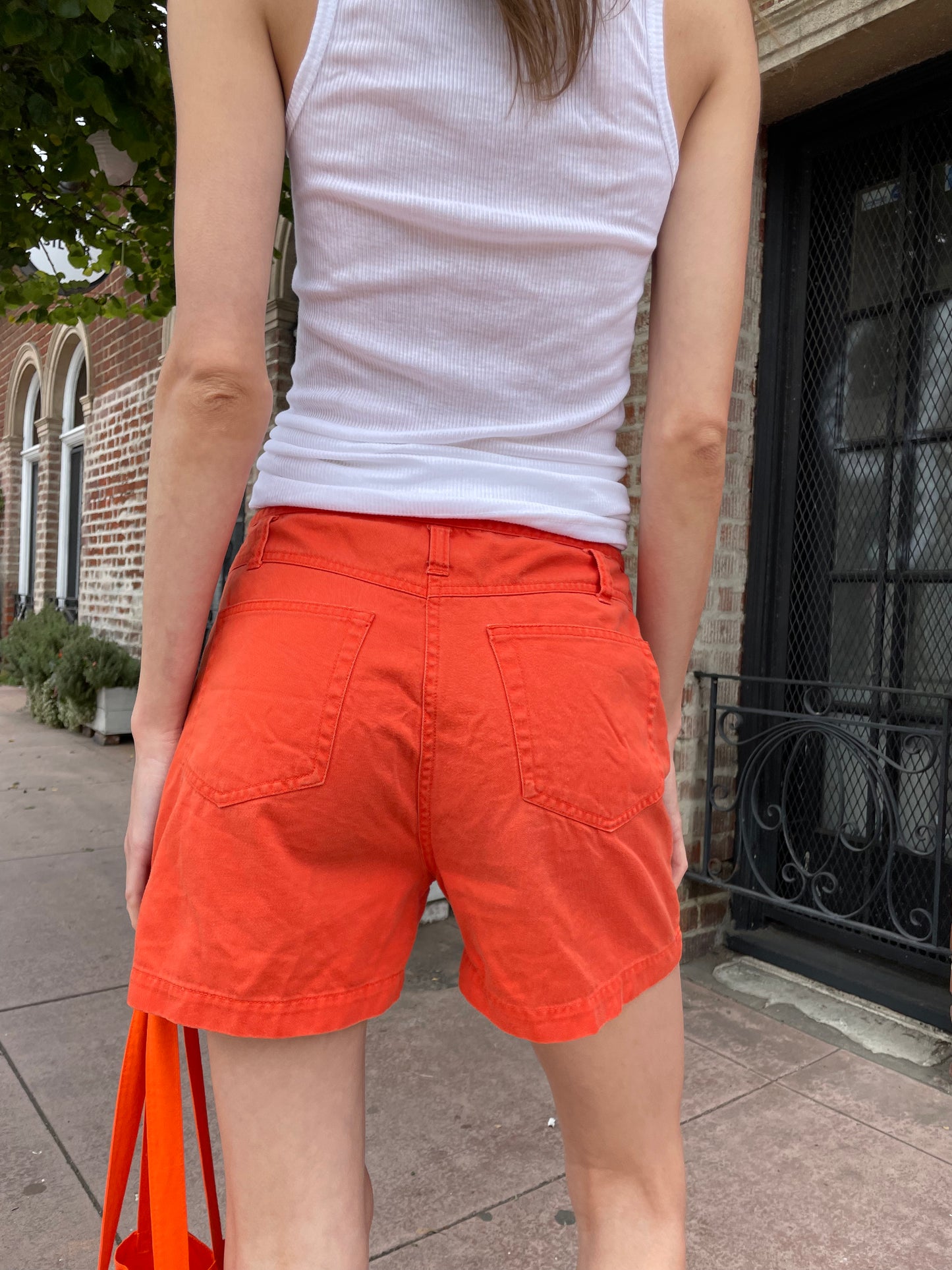 girl in white tank and orange shorts