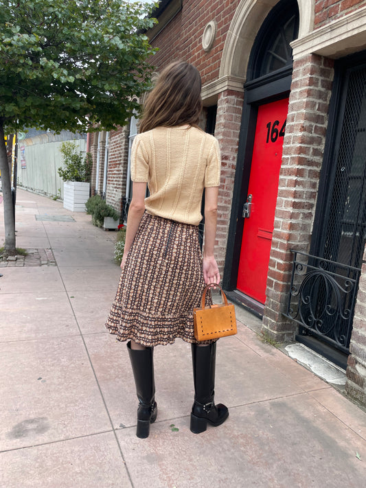 girl wearing cream sweater and brown skirt