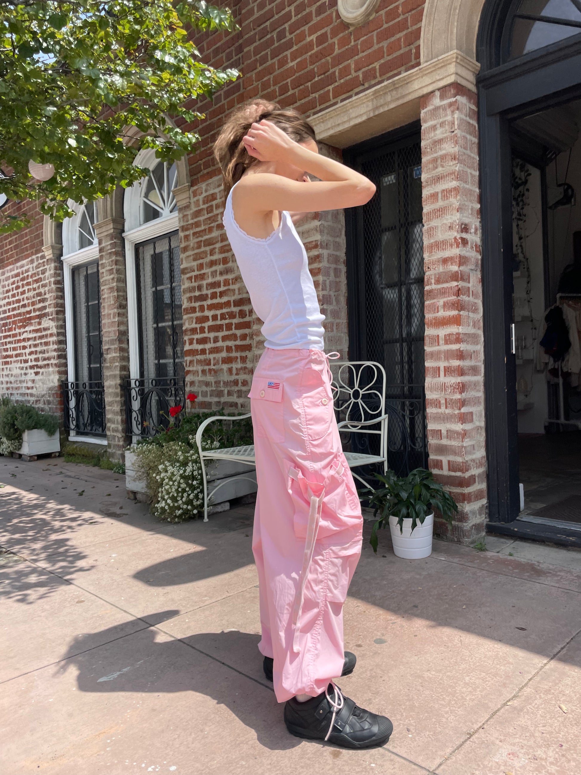 girl wearing baggy pink pants and white tank