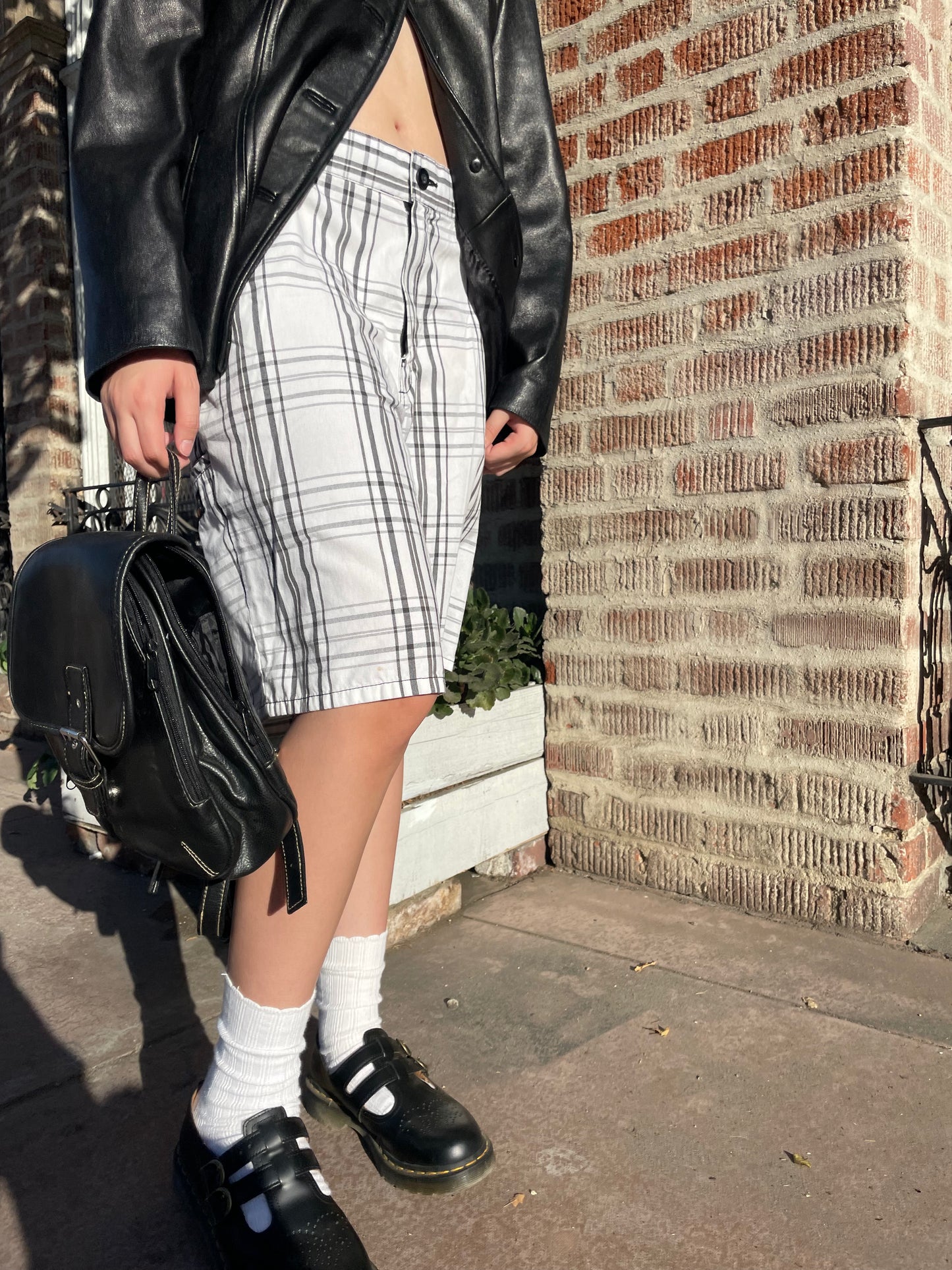 girl wearing shorts and a leather bag and jacket