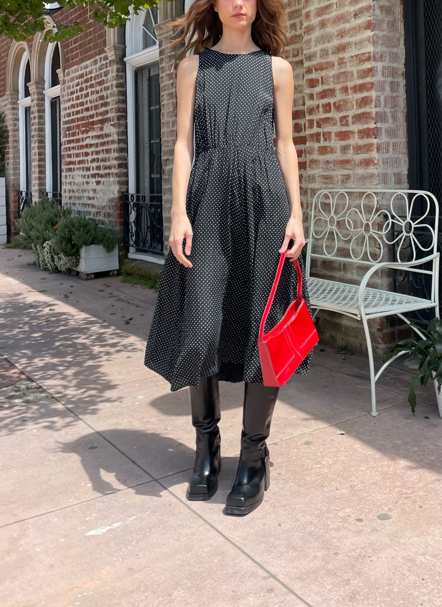 girl wearing black dress and black boots and red purse