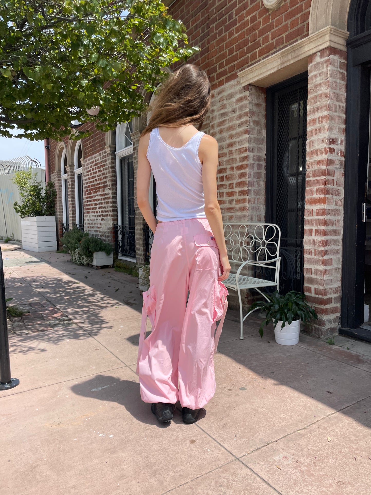 girl wearing baggy pink pants and white tank