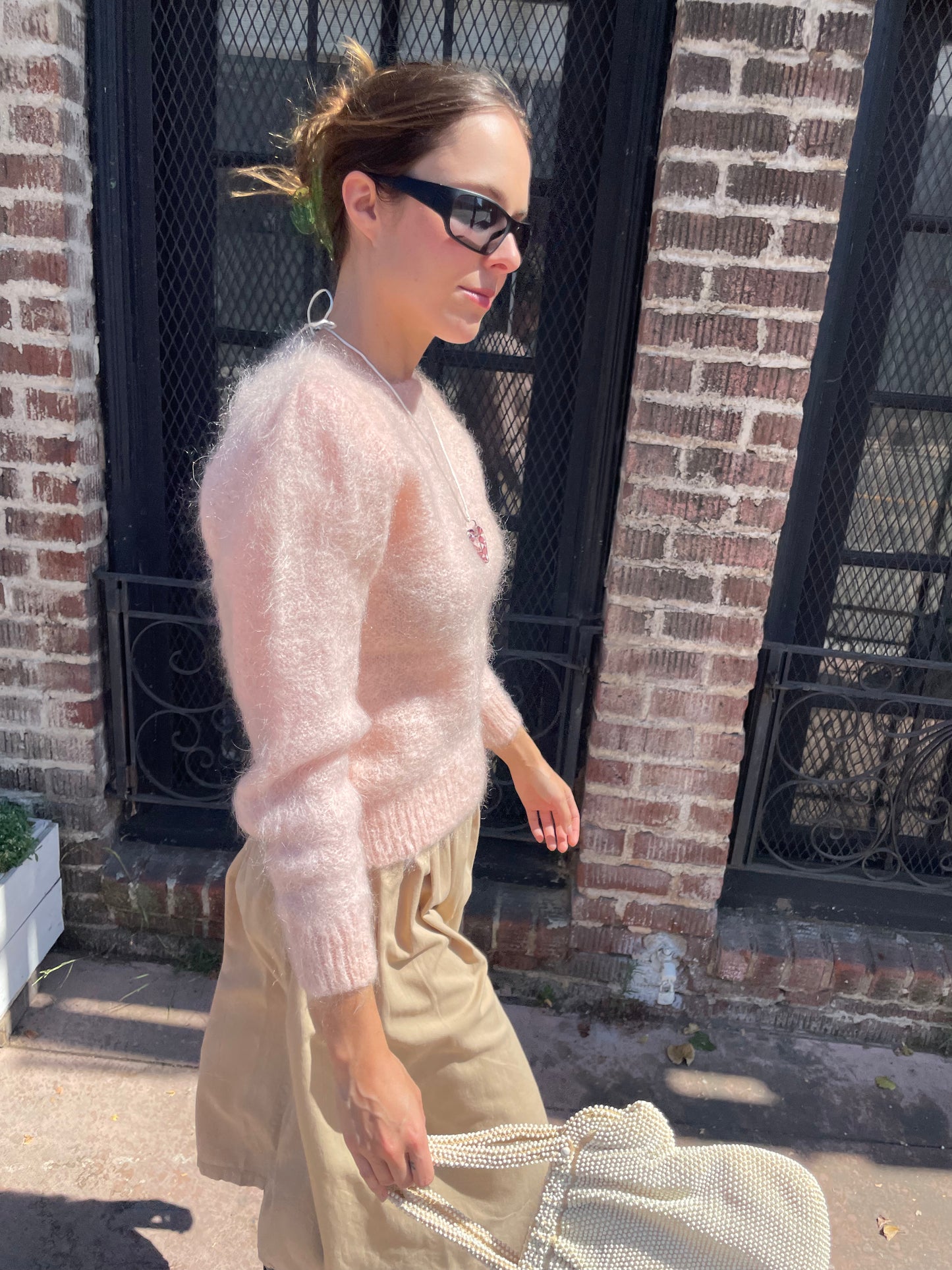 girl in tan skirt and light pink sweater