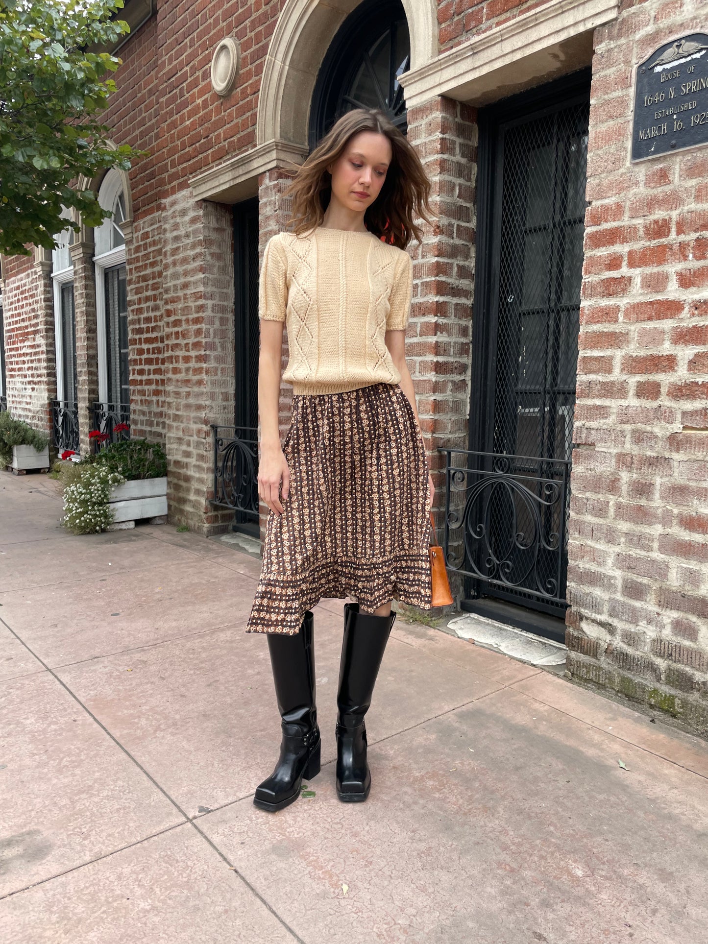 girl wearing cream sweater and brown skirt