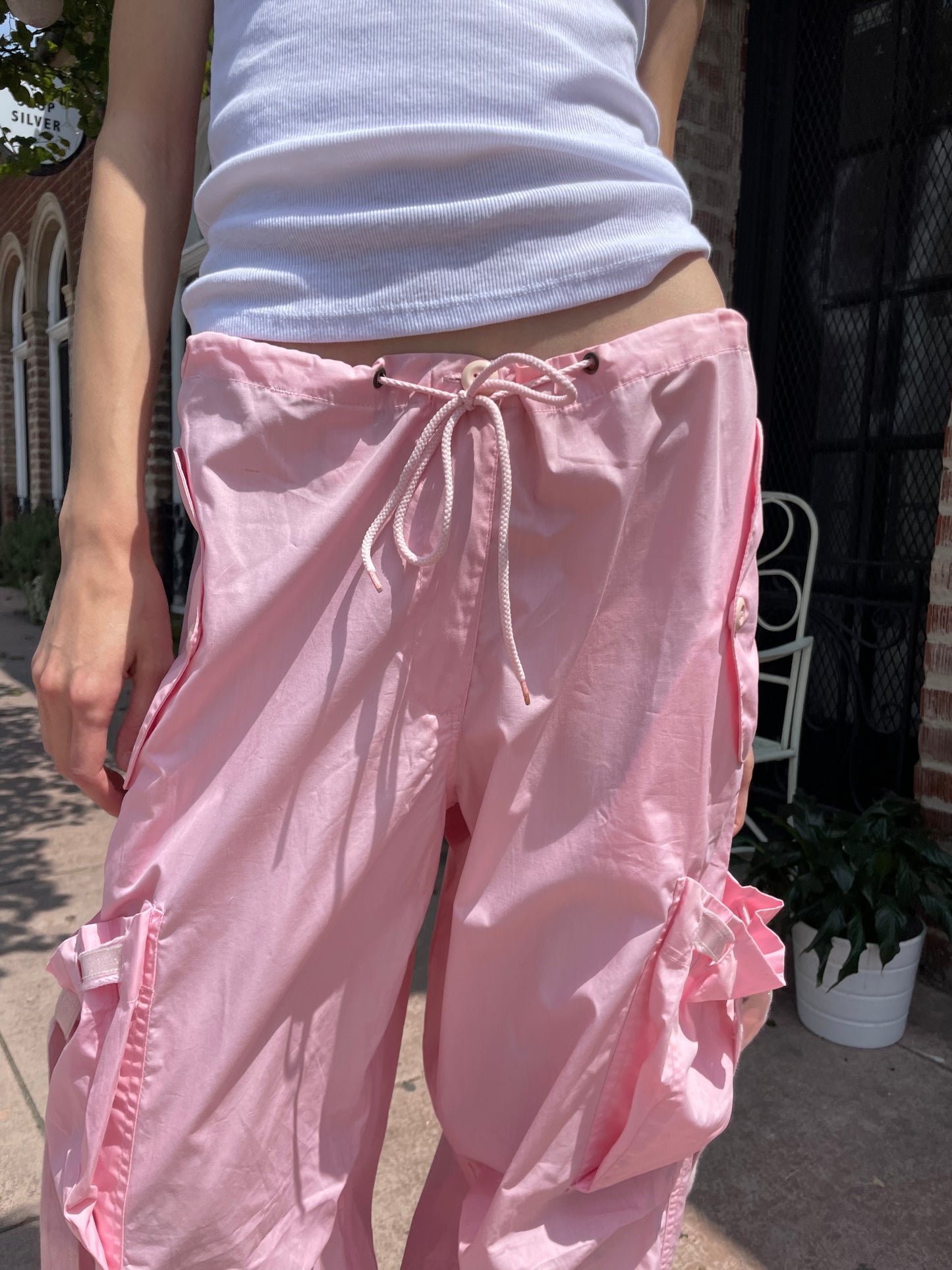 girl wearing baggy pink pants and white tank