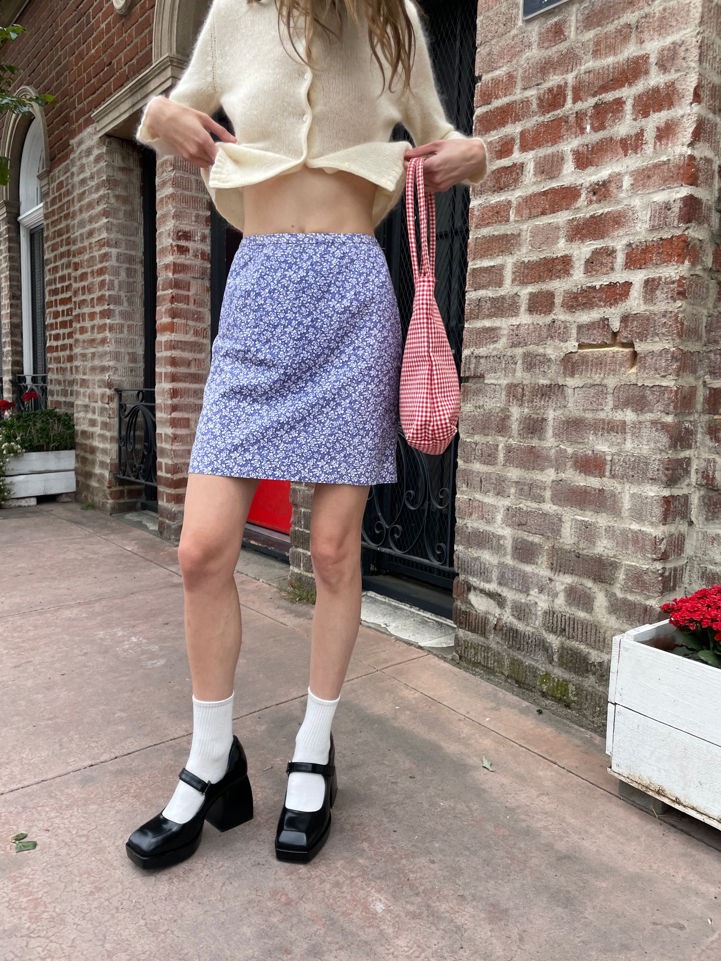 girl wearing cream sweater and violet skirt