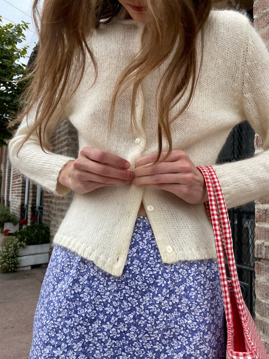girl in cream cardigan and purple skirt
