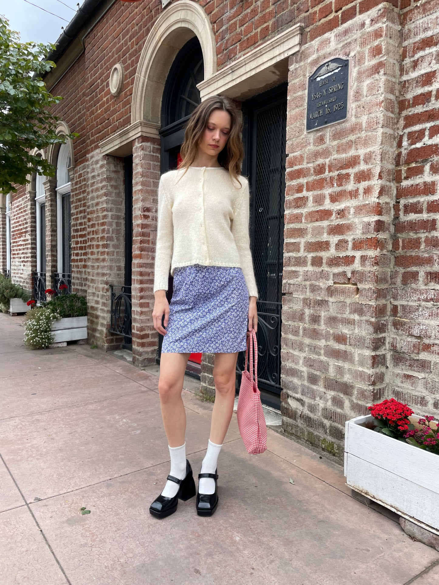 girl in cream cardigan and purple skirt