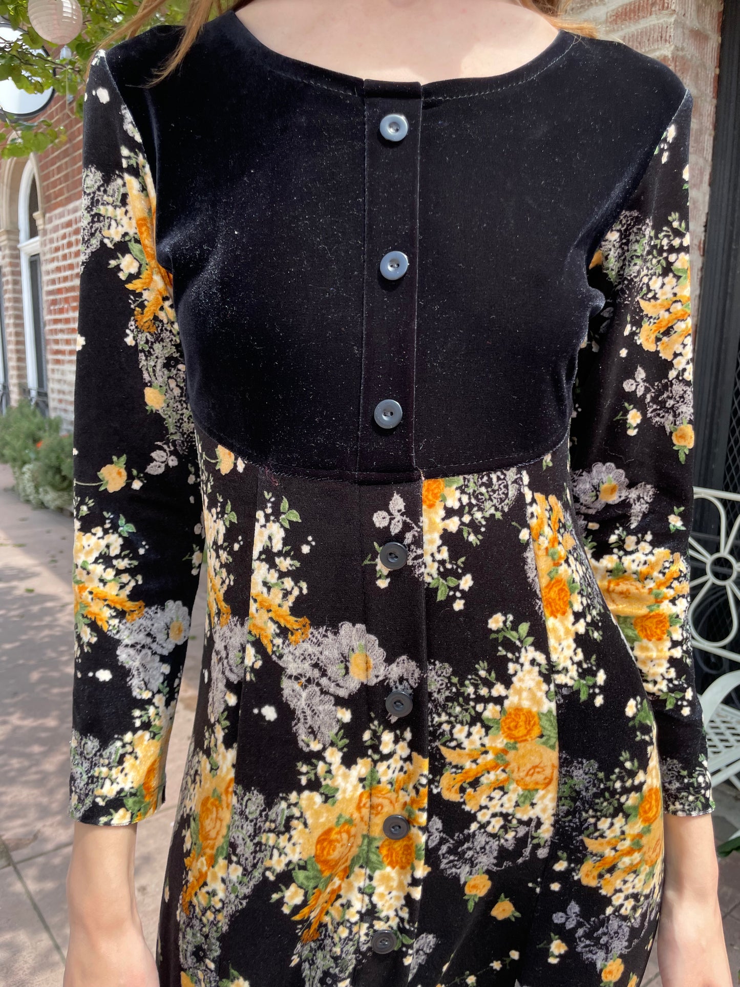 close up of girl wearing long sleeve black and yellow dress