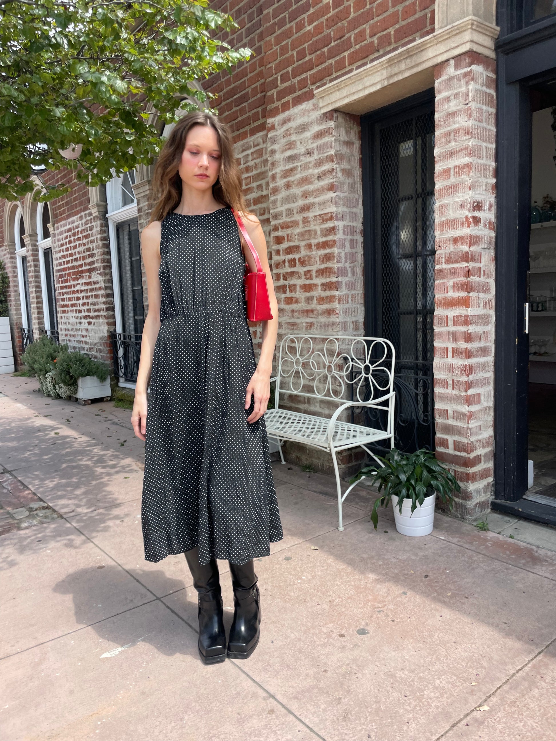 girl wearing black dress and black boots and red purse