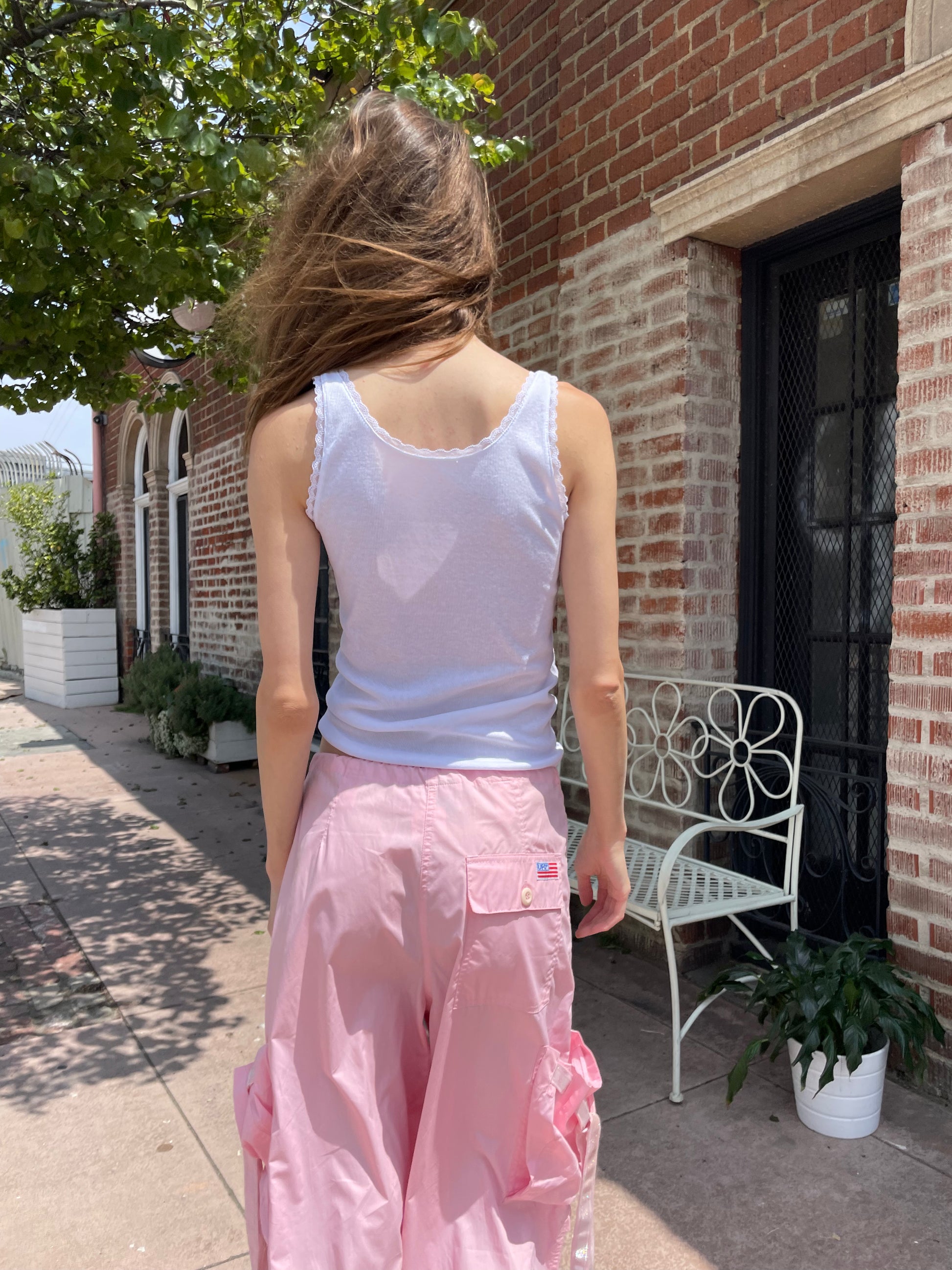 girl wearing baggy pink pants and white tank
