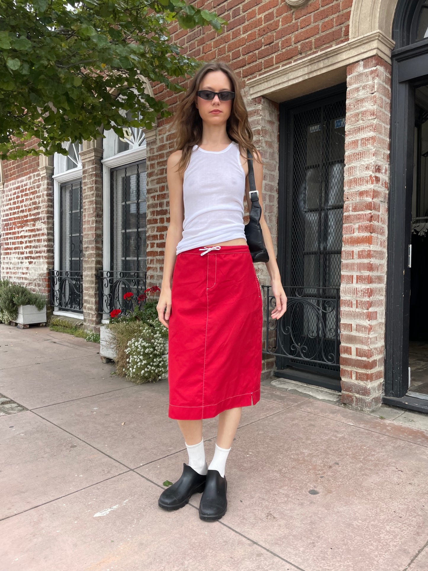 girl in red skirt and white tank top
