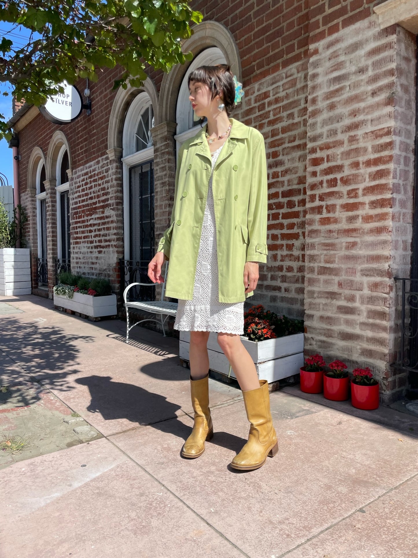 girl wearing light green pea coat and white dress