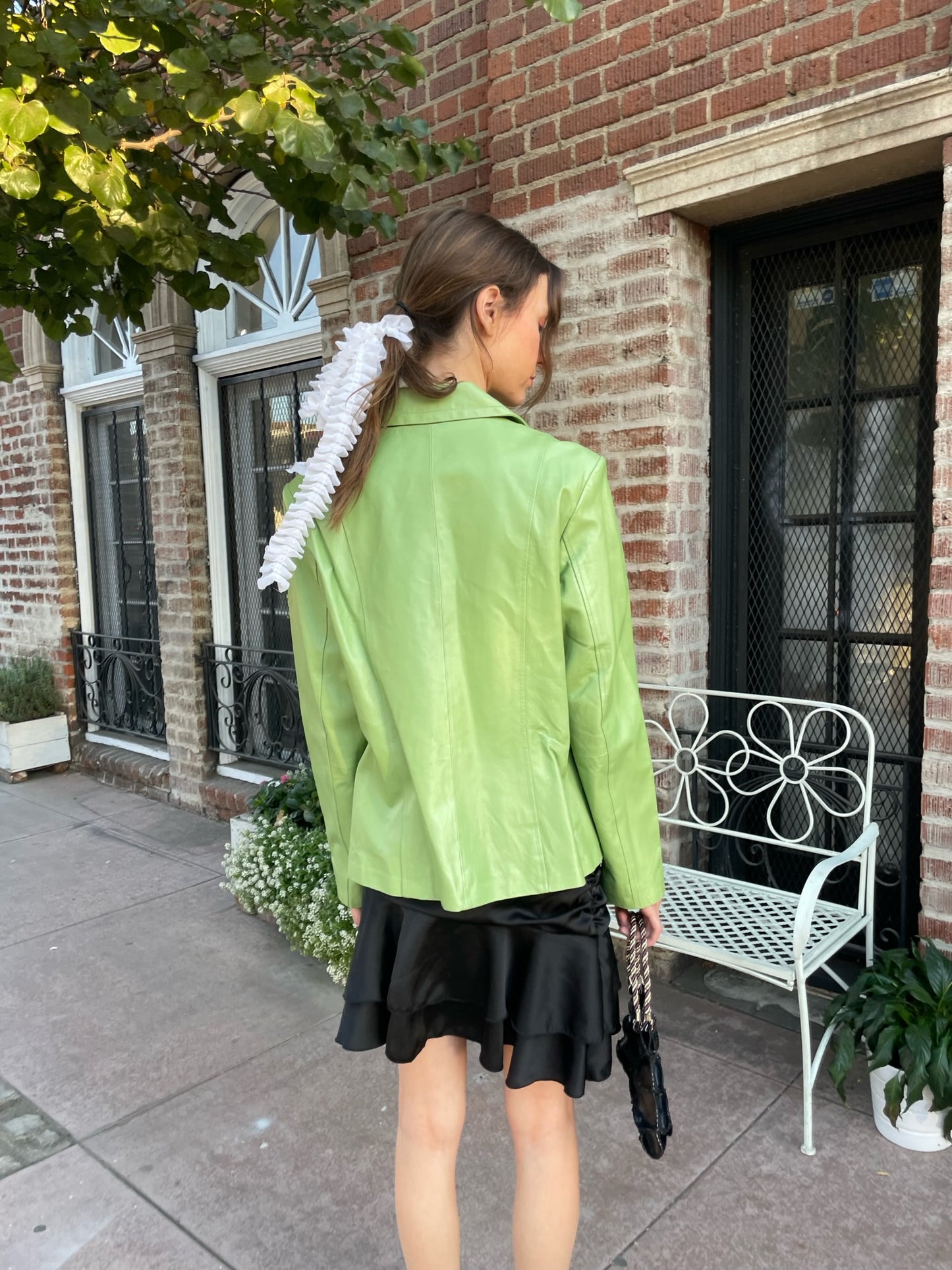 girl wearing shiny green blazer and black skirt