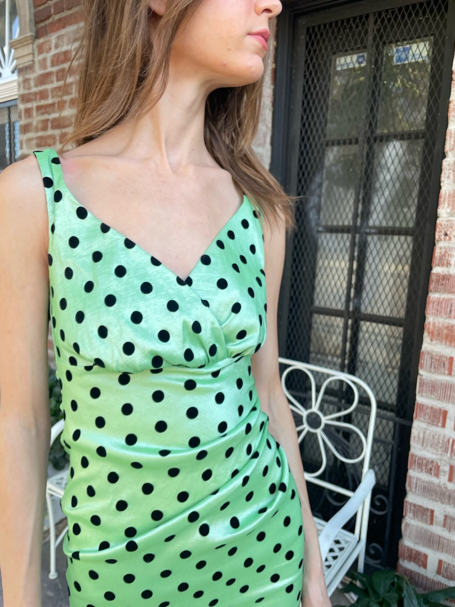 girl wearing a shiny green dress with black polka dots